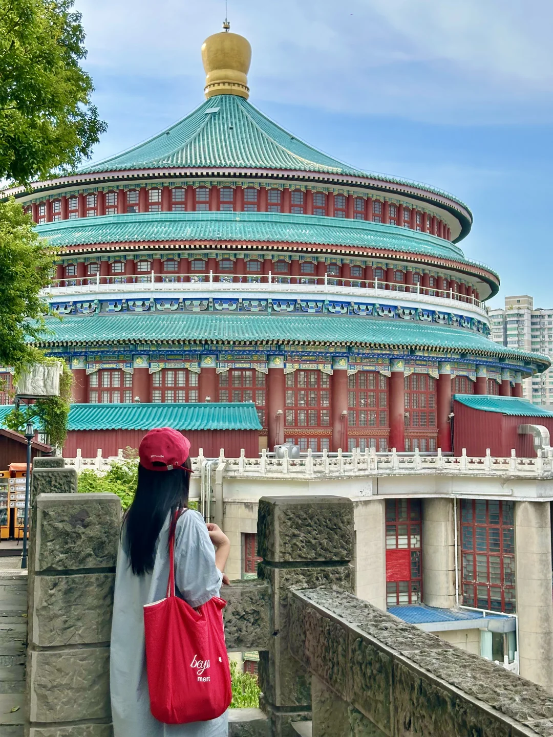 Chongqing People's Great Hall featuring a circular multi-tiered rotunda with green glazed roof tiles and red columns.